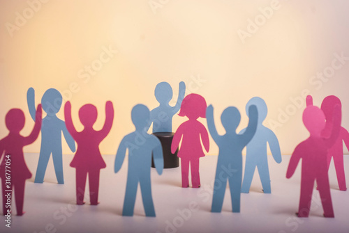 concept of strike, people protest. Society problems. Paper people standing in raised hands on a pastel background