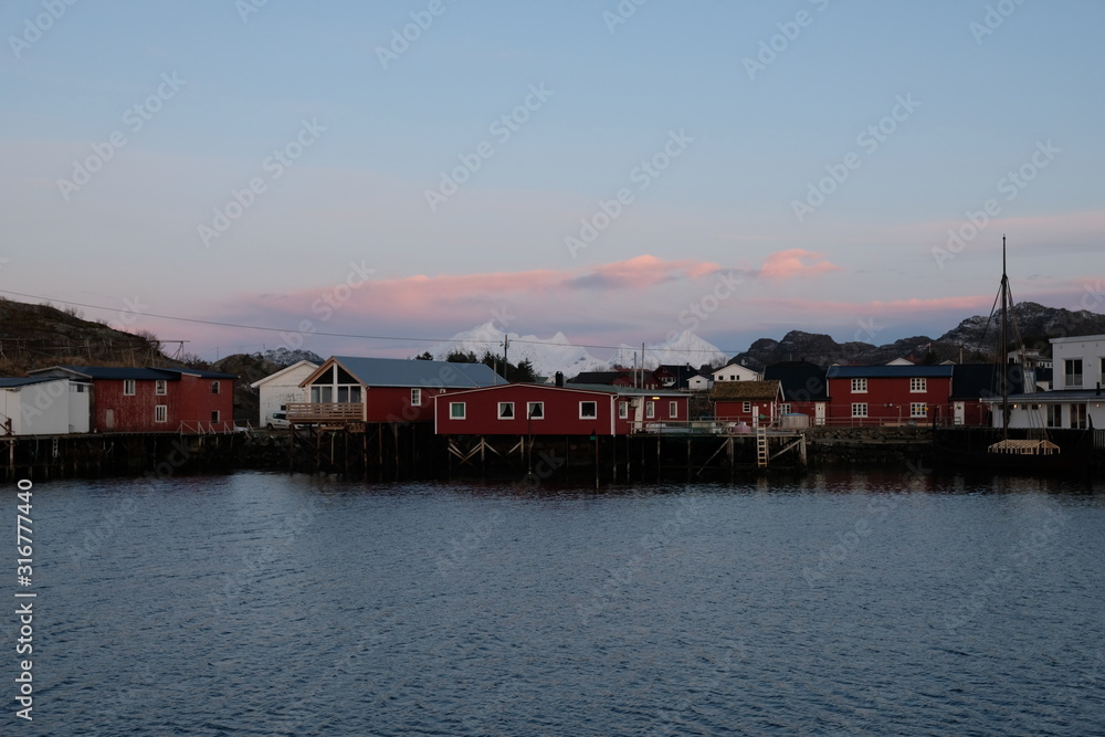 Fototapeta premium Scandinavia, Norway, Lofoten Islands, bay of fisherman village Ballstad. Mountains in the background. An unique nature. Typical red rorbu houses. 