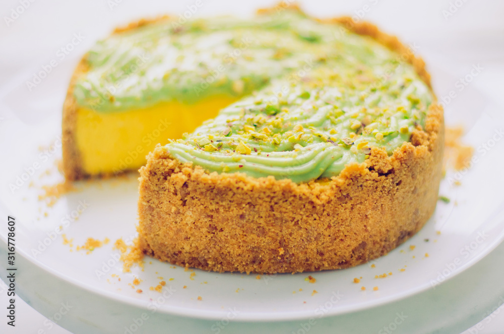 Homemade pistachio Cheesecake on white plate Homemade pistachio Cheesecake on white plate