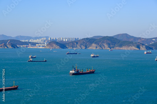 shipping cargo and fishing boat and building with mountain background