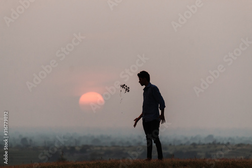 Foto Silhouette of a man jumping in front of the sun during sunset