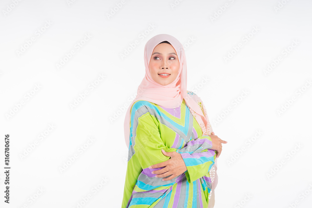 Beautiful female model wearing a pastel batik kaftan/caftan, a traditional dress for Muslim women isolated over white background. Stylish Muslim female hijab fashion lifestyle portraiture concept. Beautiful female model wearing a pastel batik kaftan/caftan, a traditional dress for Muslim women isolated over white background. Stylish Muslim female hijab fashion lifestyle portraiture concept.