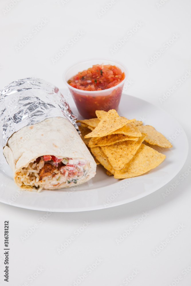 Plate of meat wrap and nachos with sauce over white background Plate of meat wrap and nachos with sauce over white background