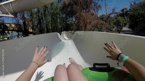 Girl going down waterslide on tube 