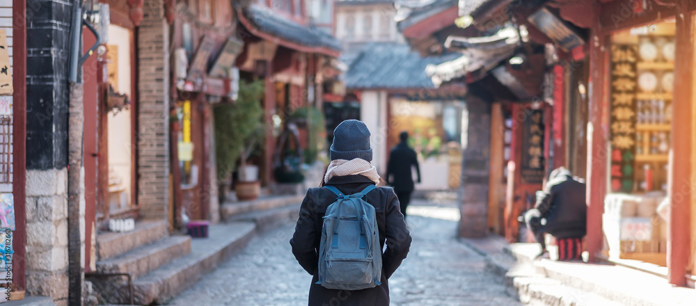 young woman traveler traveling at the Square street in Lijiang Old Town, landmark and popular spot for tourists attractions in Lijiang, Yunnan, China. Asia travel concept young woman traveler traveling at the Square street in Lijiang Old Town, landmark and popular spot for tourists attractions in Lijiang, Yunnan, China. Asia travel concept