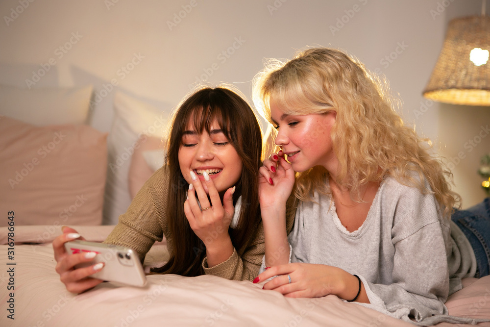 Two young girls together using mobile phone Two young girls together using mobile phone