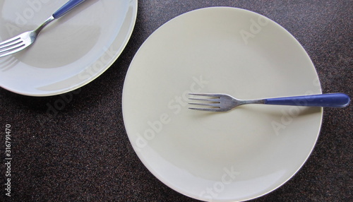 Creamy smooth plates with forks on top of a dark background