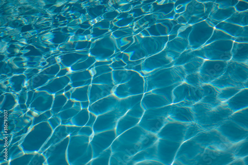 Pattern of blue water surface reflection swimming pool, Ripple wave and motion water for blue background and abstract, Bright and purified azure aquamarine turquoise water with sun reflection in pool © Markus Schmid