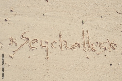 The word Seychelles written in the sand on Mahe beach