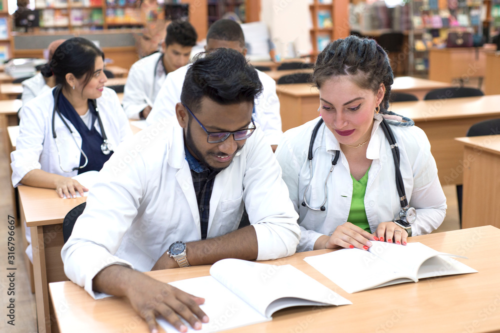medical university students. A multinational group of young people, while in the classroom, is studying medical literature, taking exams medical university students. A multinational group of young people, while in the classroom, is studying medical literature, taking exams