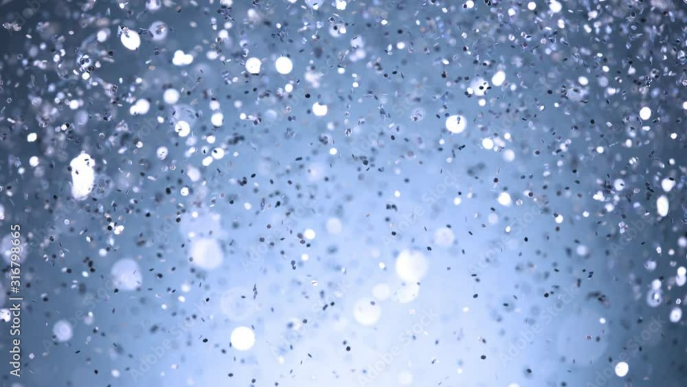 Super slow motion of glittering silver particles on black background. Shallow depth of focus. Filmed on high speed cinema camera, 1000 fps. Super slow motion of glittering silver particles on black background. Shallow depth of focus. Filmed on high speed cinema camera, 1000 fps.