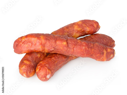 Stack of cooked sausages close-up isolated on white background.