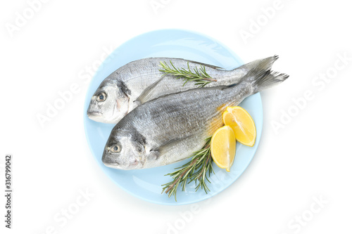 Plate with Dorado fishes, lemon and rosemary isolated on white background