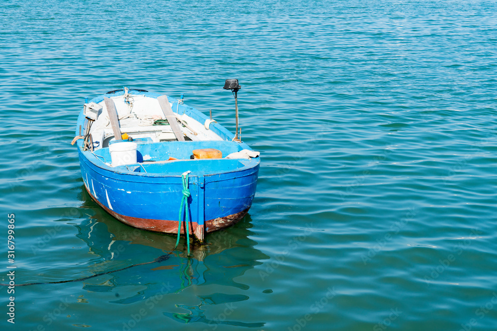 blue wooden fishing boat in the harbour of Molfetta, Italy