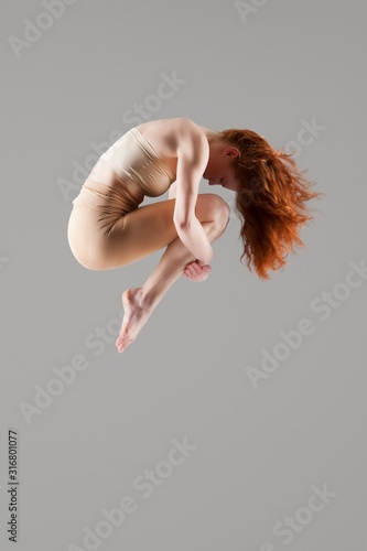 Dancer in mid-air with arms around knees photo