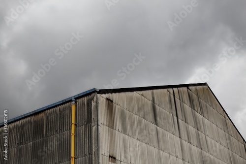 Corrugated metal building exterior with yellow drainpipe