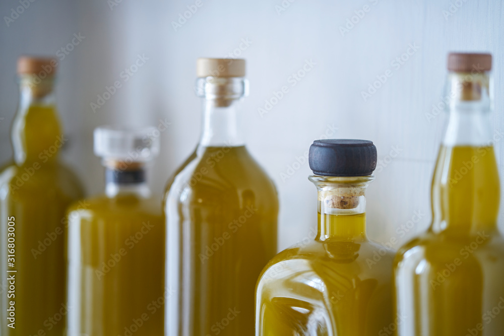 still life, bright and sunny detail of bottles blurred in shel house with reflections liquid olive oil, organic fresh raw warm closeup