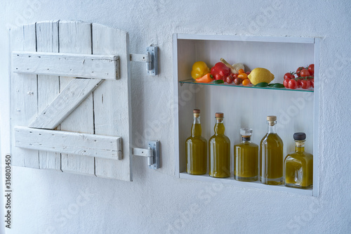 small shelf on the wall with bottles bottle olive oil and vegetables tomatos lemon paprika and garlic,old house apartment modern living barn shutter country style mood photo