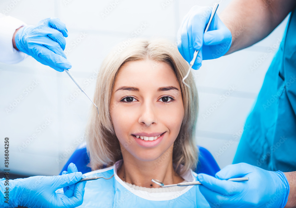 Dentists examinating blond smiling girl Dentists examinating blond smiling girl