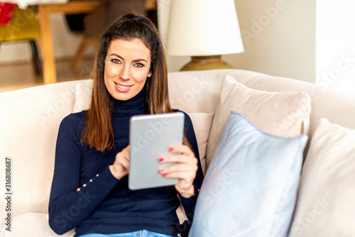 Woman relaxing on the sofa and using her digital tablet © gzorgz