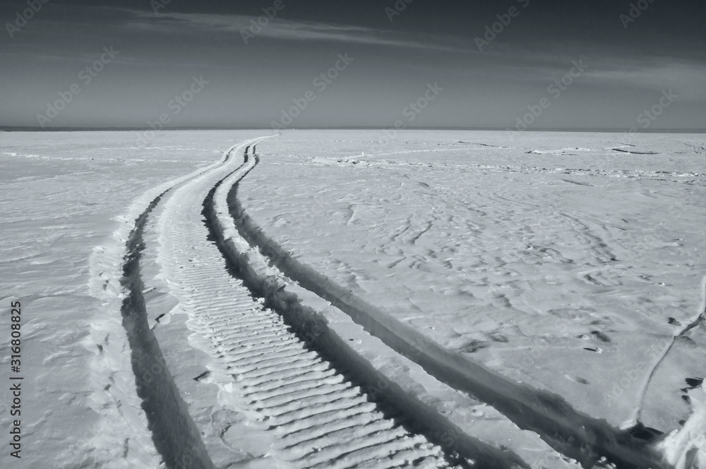 Footprints in the snow, frost, sunny weather, black and white photo.