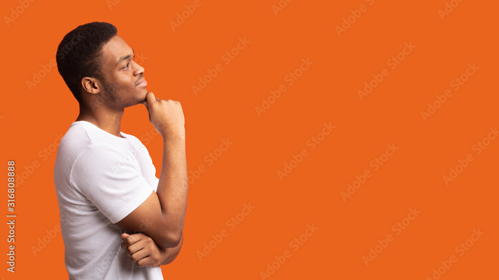 Pensive afro man profile portrait on orange background - obrazy, fototapety, plakaty 
