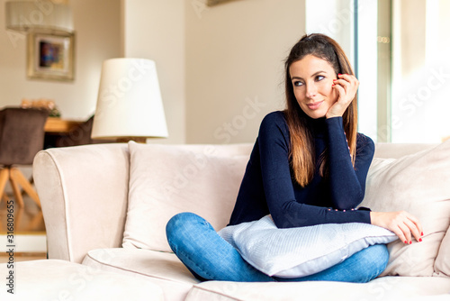 Relaxed woman sitting on comfortable sofa at home