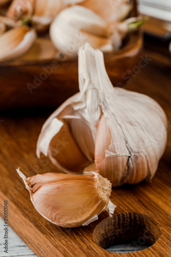 Garlic on a rustic table in a wooden bowl. Fresh peeled garlic.