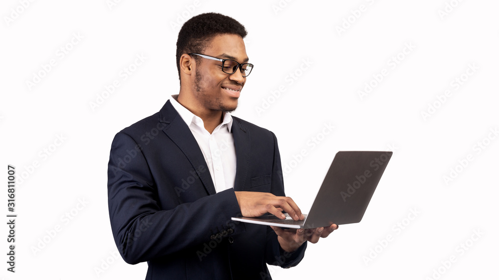 Smiling african american guy holding personal computer Smiling african american guy holding personal computer