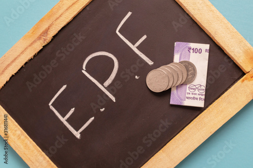 EPF or Employee provident Fund written on black slate with Indian Currency notes and Coin photo