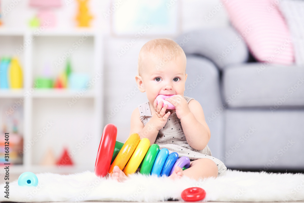 Beautiful little boy sitting and playing with plastic toys at home Beautiful little boy sitting and playing with plastic toys at home