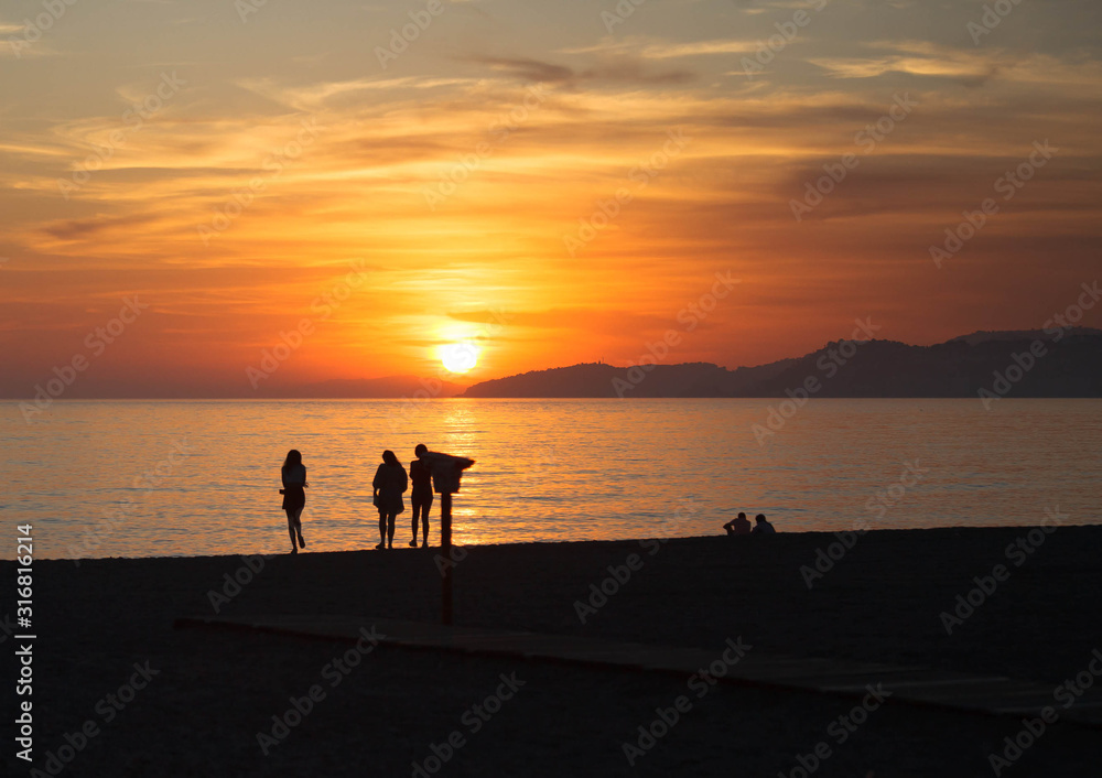 Silhouettes of people on beach at sunset in Spain Silhouettes of people on beach at sunset in Spain
