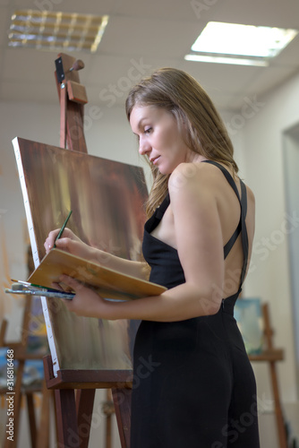 Portrait of a woman artist painting in the art studio.