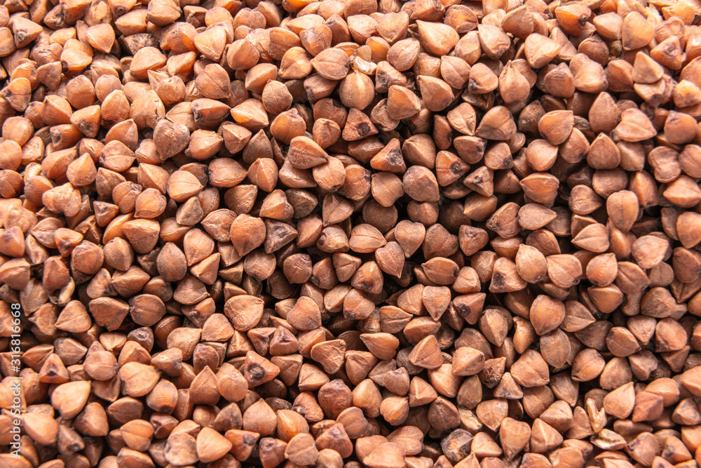 Close up raw buckwheat background, scattered cereals, healthy food Close up raw buckwheat background, scattered cereals, healthy food