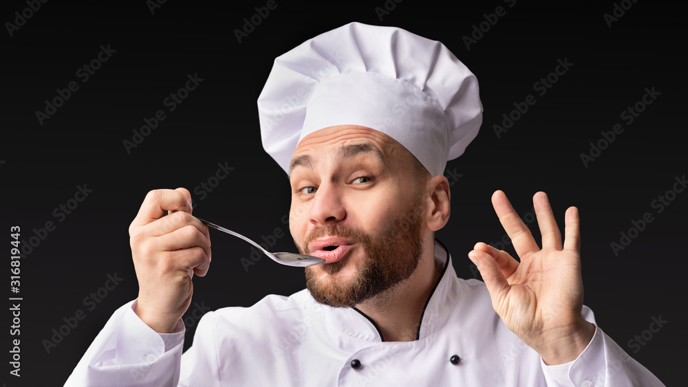 Chef Tasting And Approving Food Holding Spoon Posing In Studio Chef Tasting And Approving Food Holding Spoon Posing In Studio