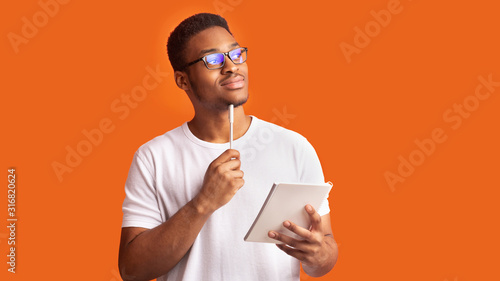 Pensive afro man portrait on orange background photo