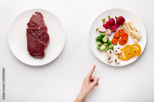 Female hand pointing at plate with organic vegetables