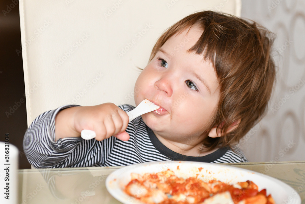 Little boy eats food from a fork in a cafe. A little boy eats food from a fork in a cafe. Family holidays, mom and son relax in a restaurant, drink cocoa and eat cake. Little boy eats food from a fork in a cafe. A little boy eats food from a fork in a cafe. Family holidays, mom and son relax in a restaurant, drink cocoa and eat cake.