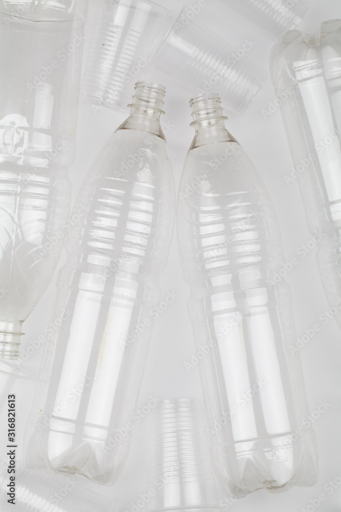 empty plastic bottles and glasses on white background.