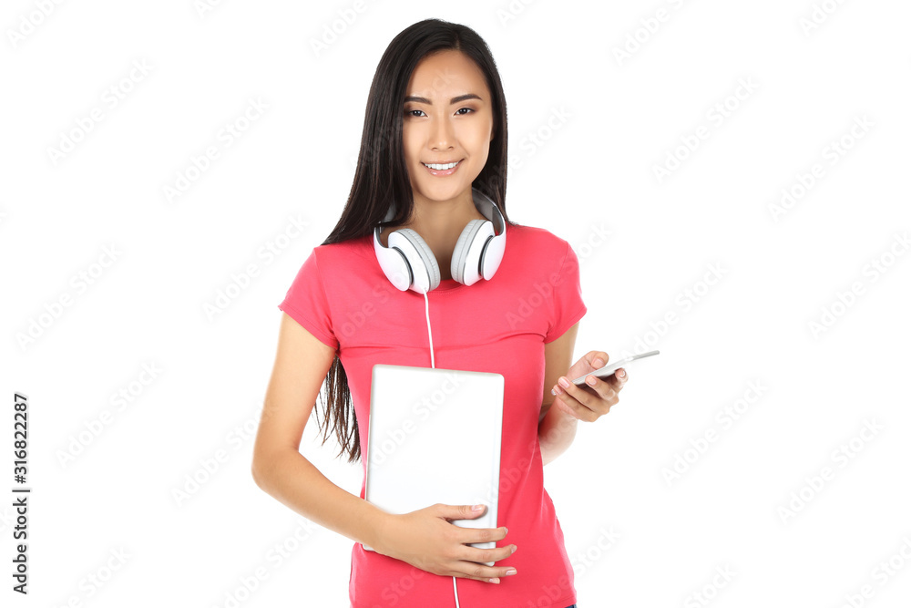Young woman with tablet pc, smartphone and headphones on white background Young woman with tablet pc, smartphone and headphones on white background
