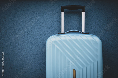 Blue travel bag on blue wall background.
