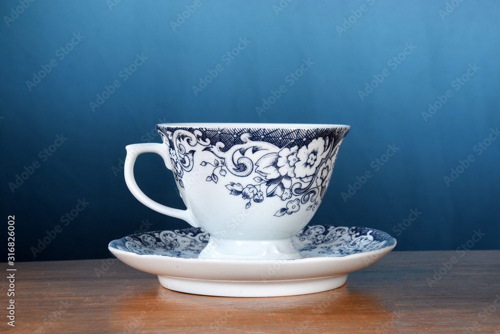 wooden table with cup of tea with rosemary branches isolated on blue gradient background with space for text. wooden table with cup of tea with rosemary branches isolated on blue gradient background with space for text.