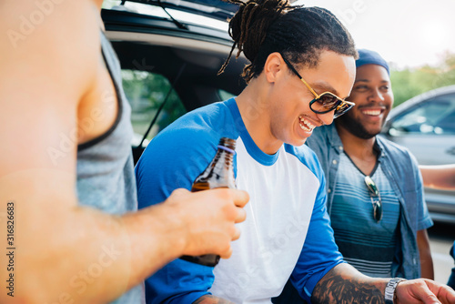 Canvas Print Friends drinking and having fun at tailgate party in sunshine.