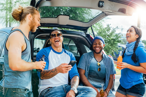 Photography Friends drinking and having fun at tailgate party in sunshine.