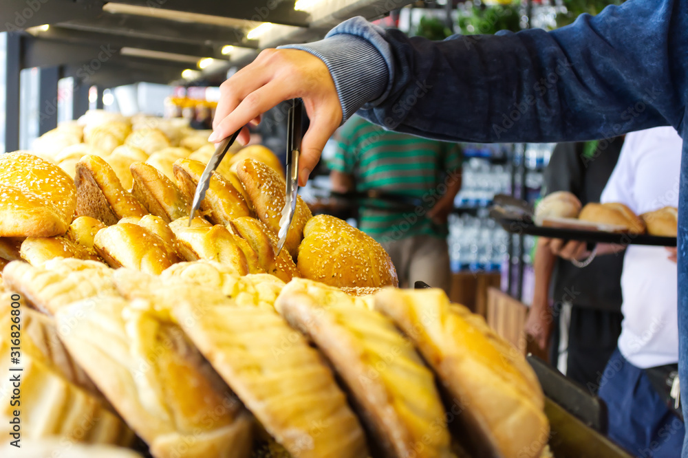Man taking bread to buy it in a bakery