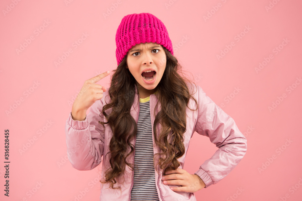 small beauty pink wall. little girl puffer jacket and knitted hat. health care in cold weather. feel the surprise. angry child in warm winter clothes. seasonal fashion for kids. Warm clothes small beauty pink wall. little girl puffer jacket and knitted hat. health care in cold weather. feel the surprise. angry child in warm winter clothes. seasonal fashion for kids. Warm clothes