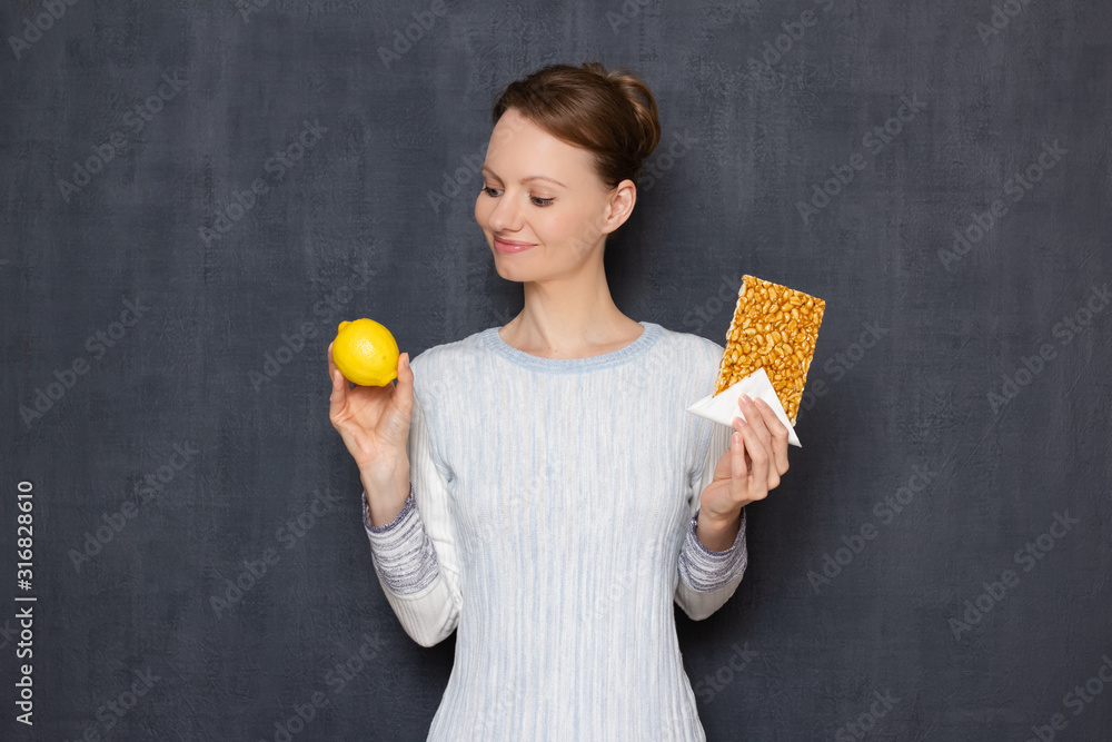 Portrait of happy positive girl holding lemon and confection Portrait of happy positive girl holding lemon and confection