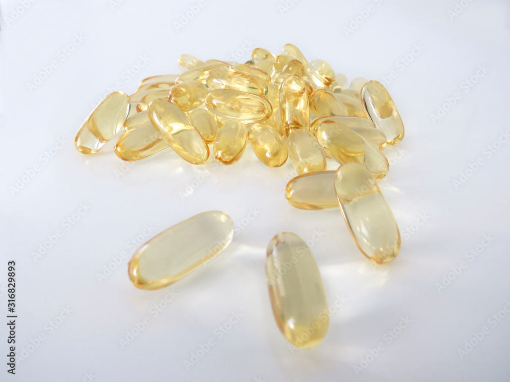 Omega 3 gel capsules isolated on white background. Macro of a bunch of yellow gel pills. Omega 3 gel capsules isolated on white background. Macro of a bunch of yellow gel pills.