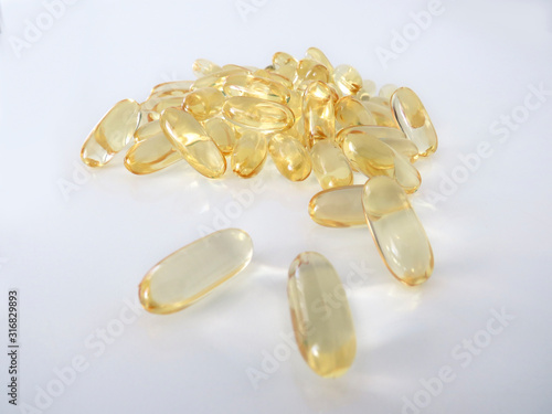 Omega 3 gel capsules isolated on white background. Macro of a bunch of yellow gel pills.