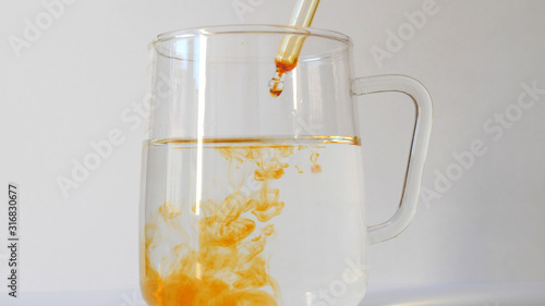 Quadro su tela Dripping Iodine into a glass of clean water. Lugol's solution.